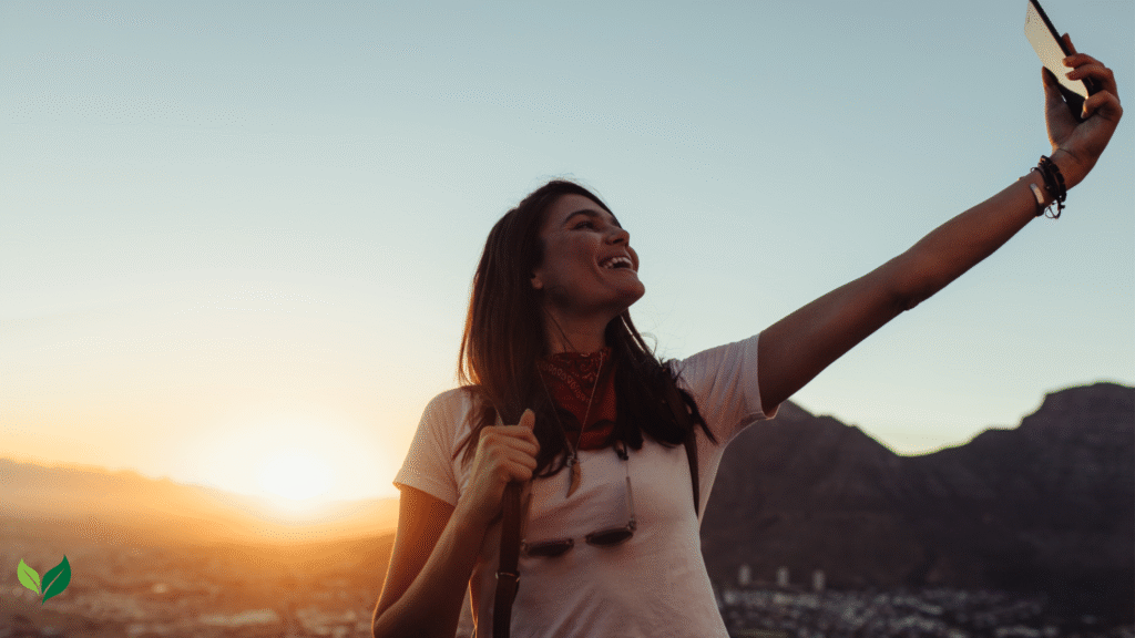 Solo female traveler taking a selfie while exploring a sustainable travel destination outdoors