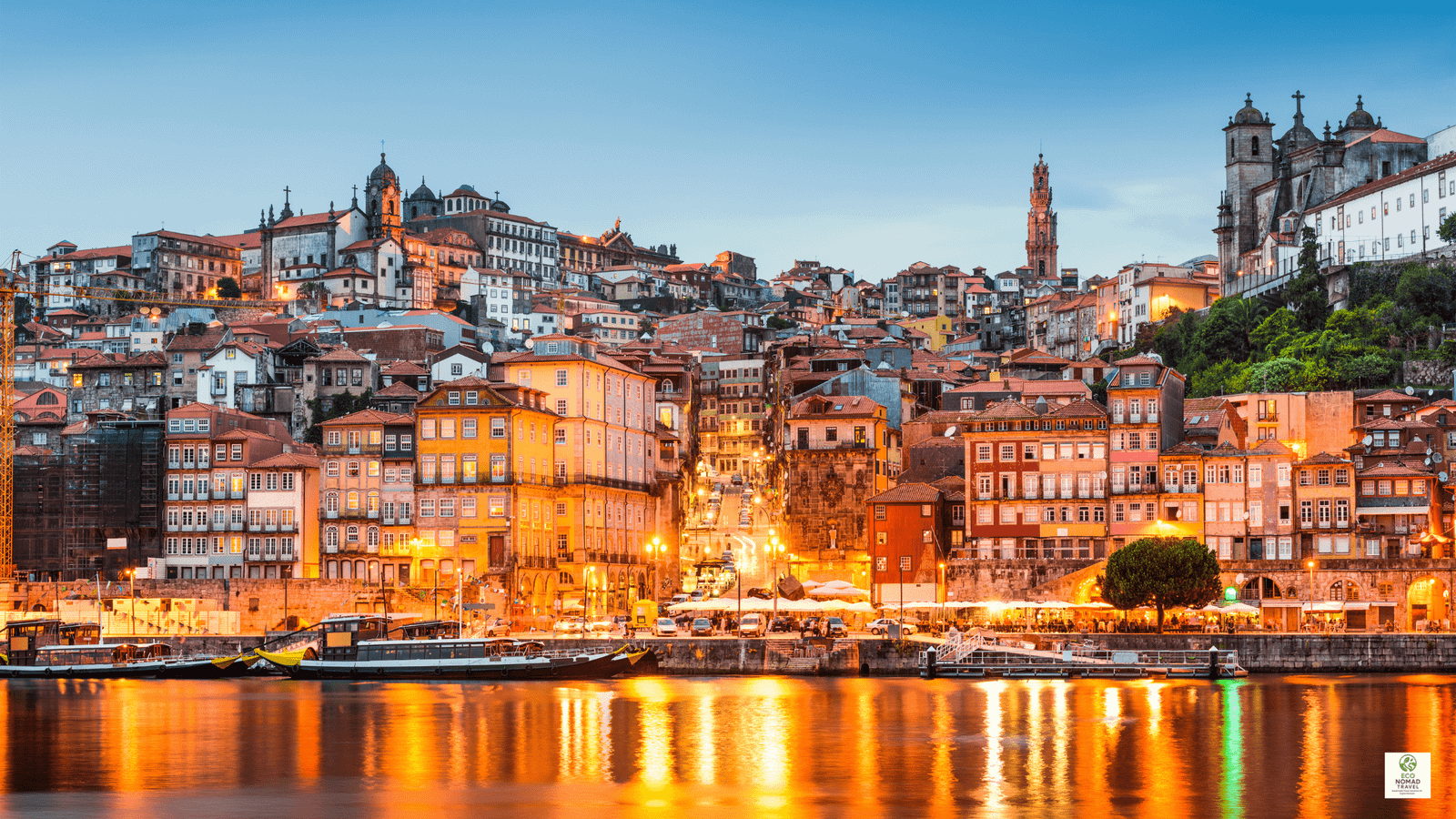 Sunset over the Douro River in Porto, Portugal, with historic houses and boats, illustrating a scenic stop on a rail-first flight-free travel itinerary in 2025