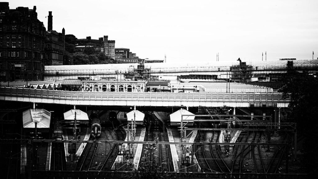 A dramatic black and white photo of an urban train station.